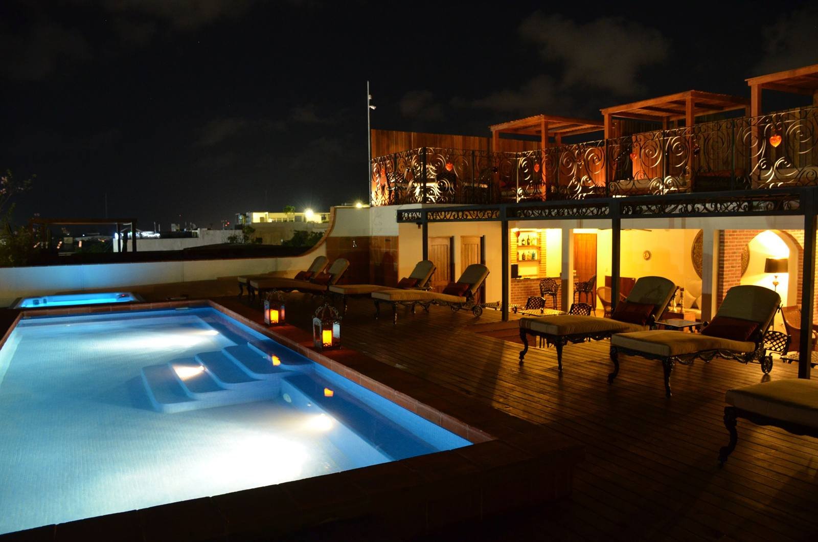La Pasión Hotel Boutique: rooftop pool and loungers lit up at night