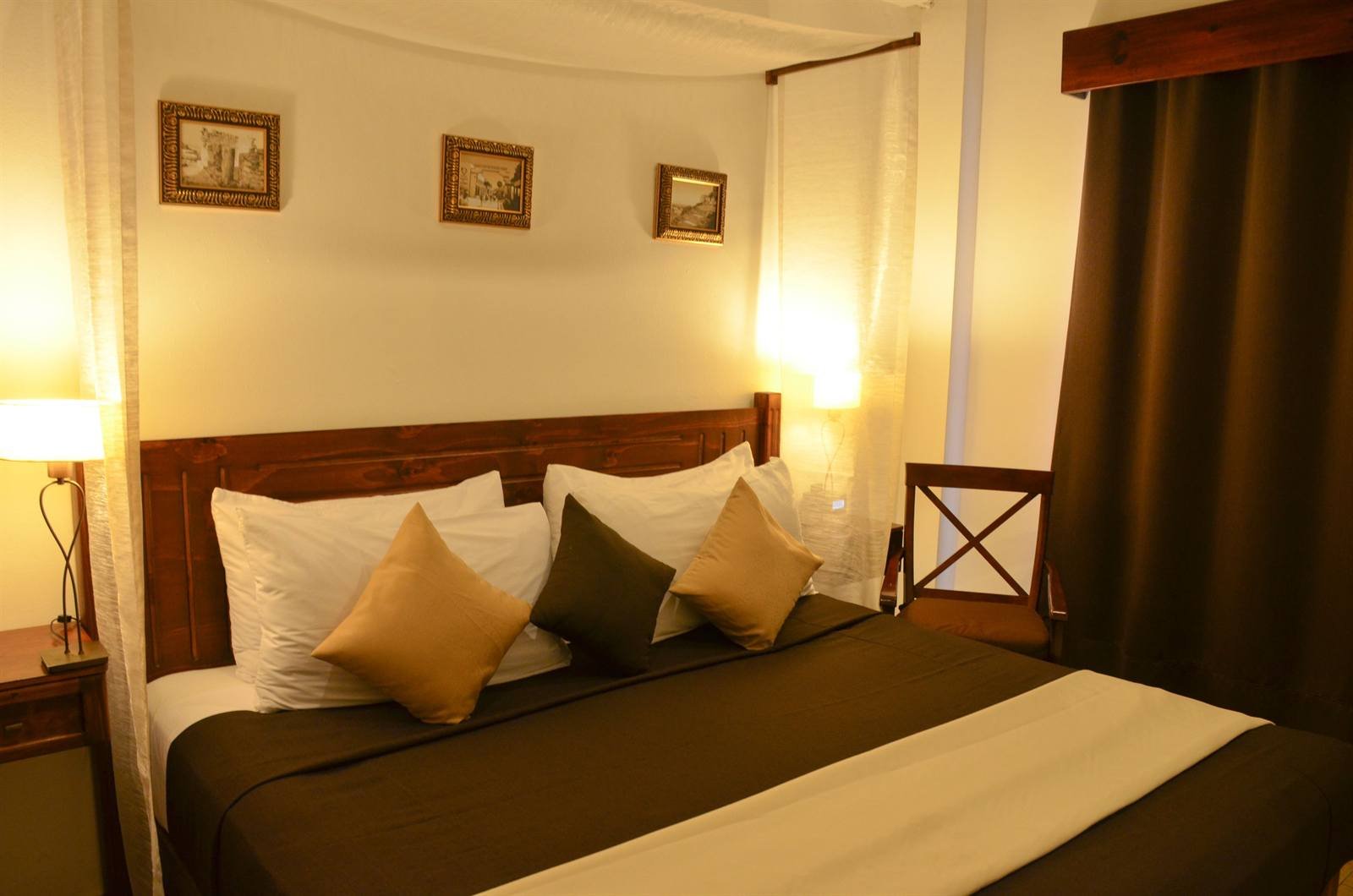 La Pasión Hotel Boutique: King room with a wooden headboard and framed prints